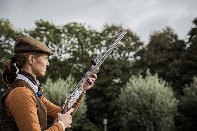 Woman holding a shotgun with a Acro S-2 sight